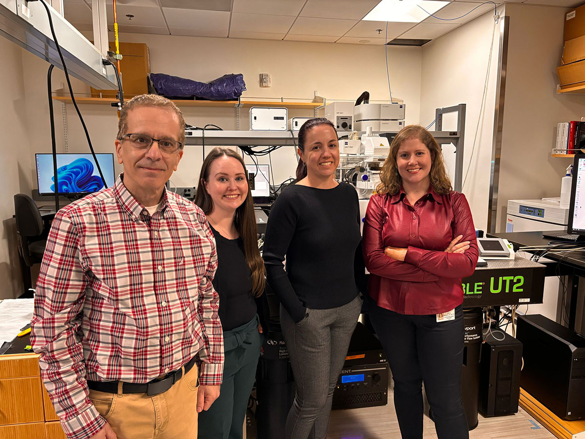 Four people standing in a laboratory