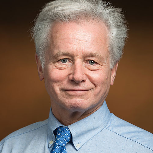 Portrait of Volkmar Weissig wearing a light blue collared shirt with a blue necktie
